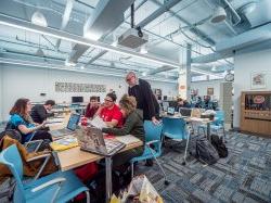 A faculty member helping some students in a design lab.